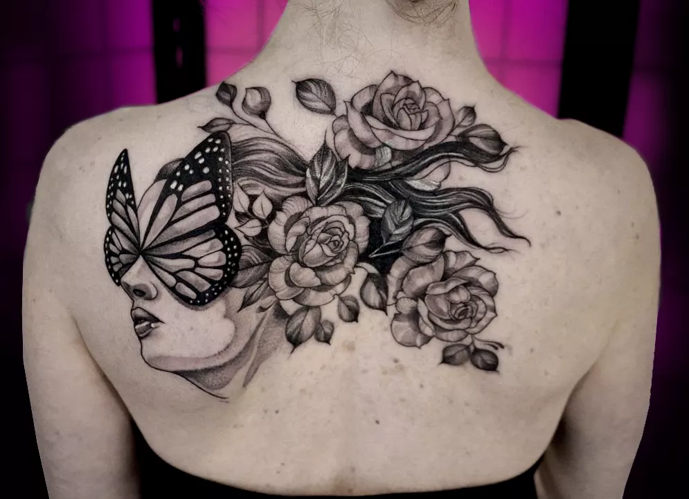 Large black and grey back tattoo by Abby at Tattoo Abyss Montreal featuring woman portrait with butterfly and roses