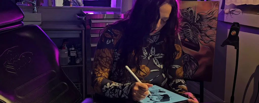 Tattoo artist Abby drawing a custom tattoo design on a tablet at Tattoo Abyss in Montreal