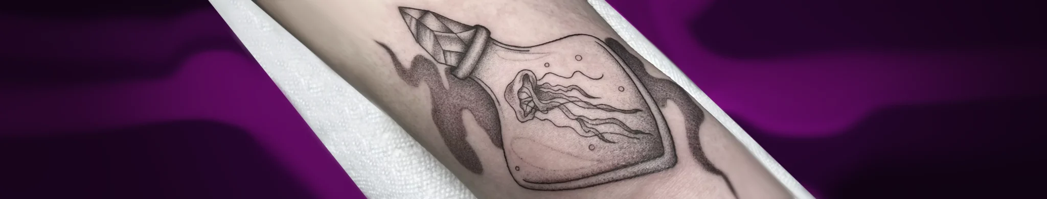 Fine line jellyfish in a bottle tattoo with dotwork shading by Alina – Montreal fine line tattoo artist at Tattoo Abyss